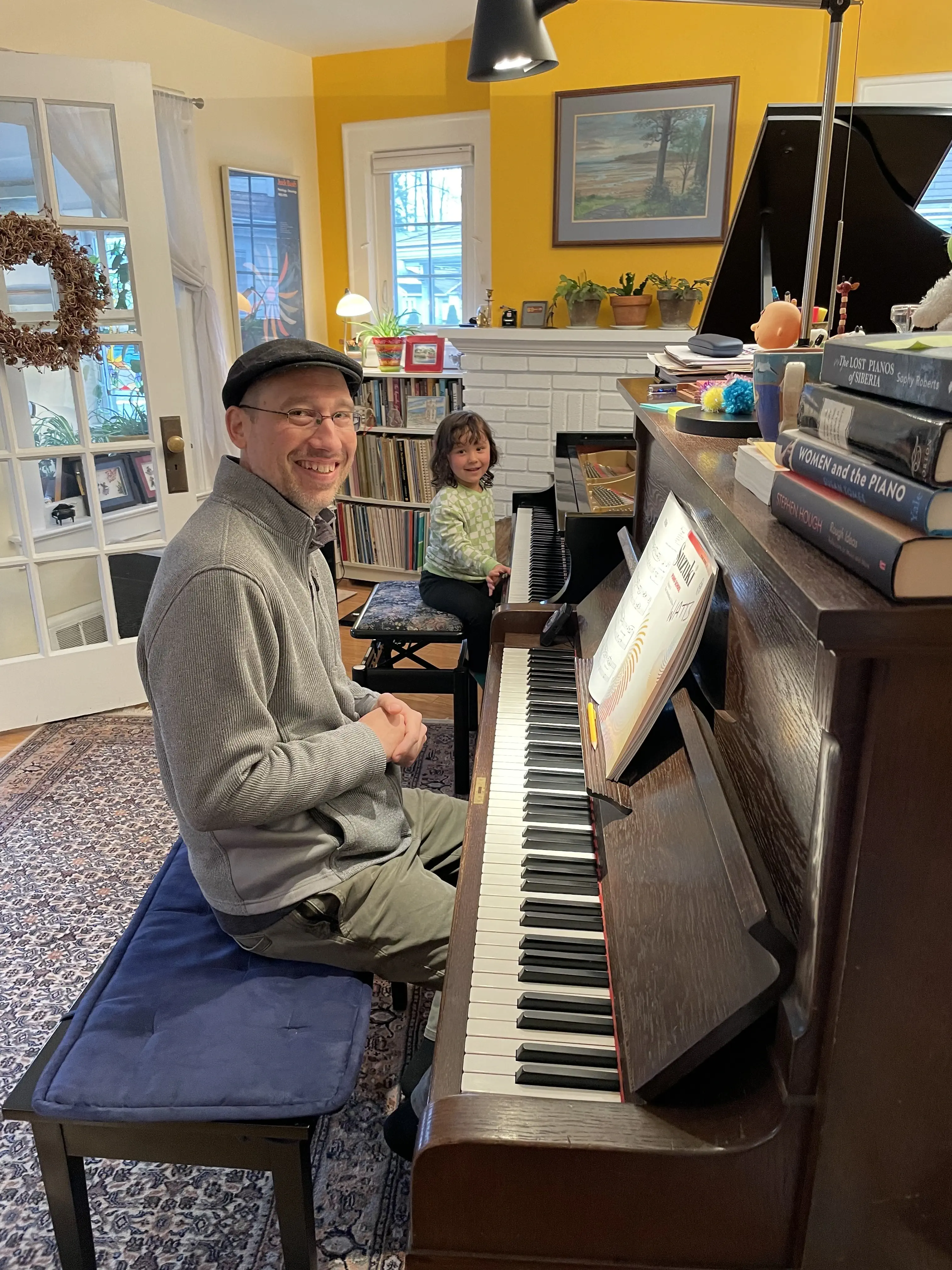 father and daughter sitting at two pianos