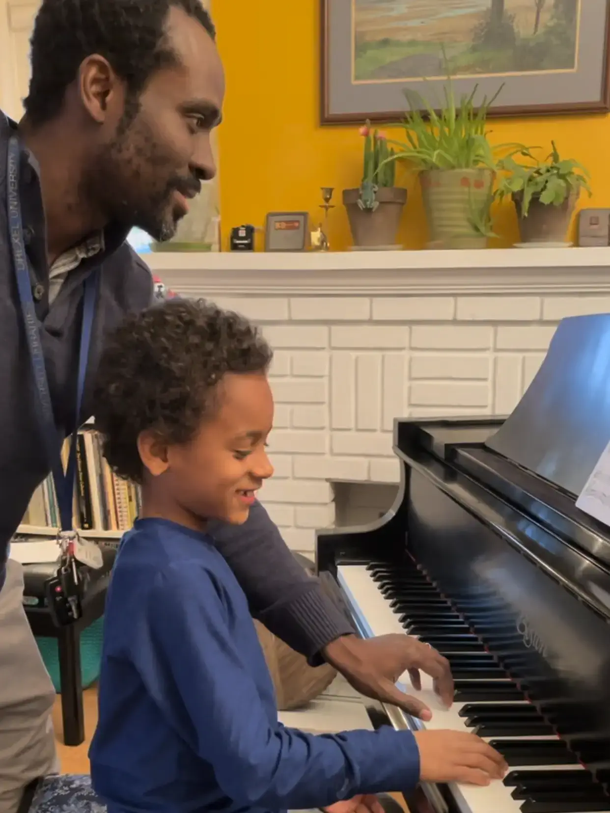 parent playing piano with their child